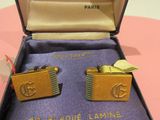 deux paires de boutons de manchette dans un coffret posé sur une table