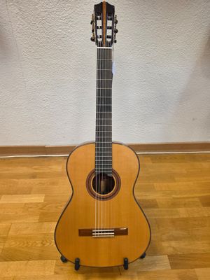 an acoustic guitar sitting on top of a wooden floor next to a wall
