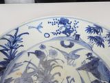 a blue and white plate with birds and flowers on it