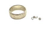 an image of a close up of a ring and earring on a white surface
