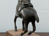 a statue of a man riding a horse on a wooden block