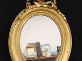 a mirror with a bow around it on a table