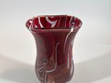 a red vase that is sitting on a white surface