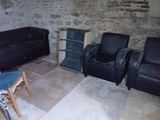 plusieurs chaises et une table dans une pièce dont l'un des murs est en briques