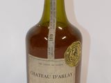 Une vieille bouteille de Château d'Orlay est posée sur une surface blanche.