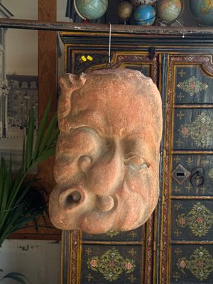 a sculpture of a face on a cabinet in a room