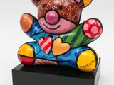 a colorful teddy bear sitting on top of a black stand