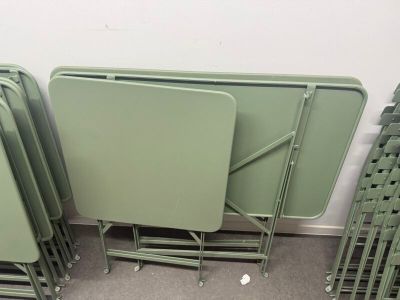 several green folding tables and chairs in a room with carpet