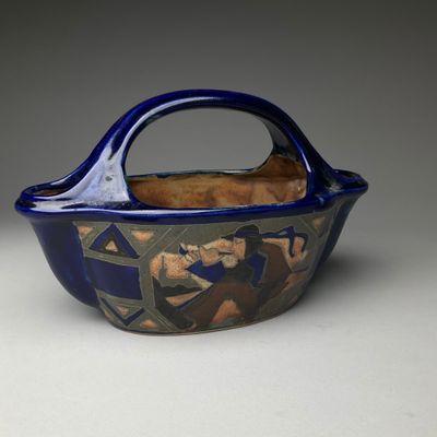un bol bleu et marron muni d'une anse, posé sur une table
