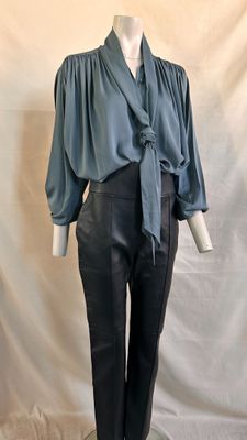 an image of a mannequin wearing a blue blouse and black leather pants