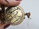 a close up of a person holding a pocket watch