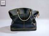 the black and gold handbag is sitting on a white surface