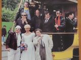 une photo d'un groupe de personnes debout devant un bus à deux étages