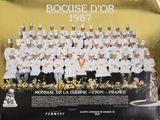 des officiers de la Marine française posant pour une photo devant une affiche recouverte de feuille d'or