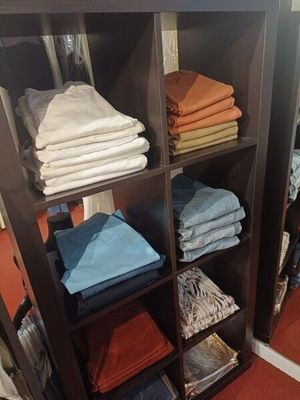 de nombreuses serviettes pliées sur une étagère dans un magasin