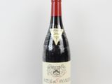 une bouteille de vin rouge posée sur une surface blanche, avec un fond blanc