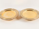 a pair of gold plated dishes on a white background