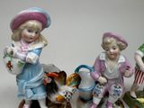 three figurines of children and a dog on a table