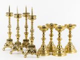 six brass candlesticks and a candle holder on a white background