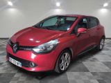 une voiture rouge est garée dans une pièce au sol en damier