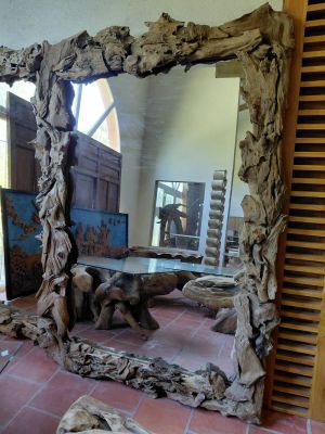 a large mirror that is made out of drift wood