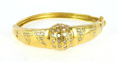 a close up of a gold bracelet with diamonds on it