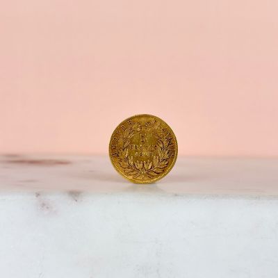 a gold coin sitting on top of a marble counter top