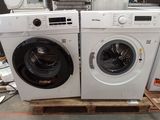 deux machines à laver posées l'une à côté de l'autre sur une palette