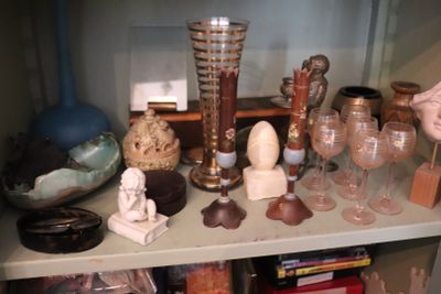 a shelf that has many different types of glass on it