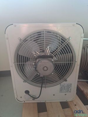 un ventilateur posé sur une palette dans une pièce