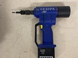 an electric drill is sitting on the floor next to a piece of paper