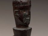 a close up of a wooden object with a face on it