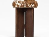 a brown and white cowhide stool with wooden legs