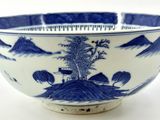 a blue and white bowl with a mountain scene on it