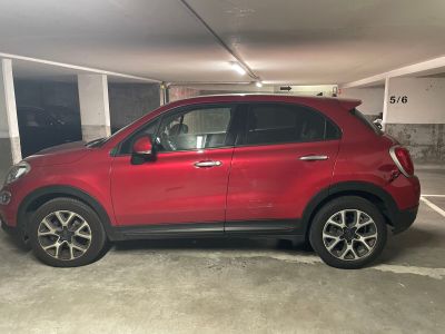 une voiture rouge garée dans un parking couvert