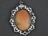 a silver pendant with an orange stone in the center