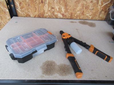 une boîte à outils contenant des outils, posée sur une table à côté d'une autre boîte à outils
