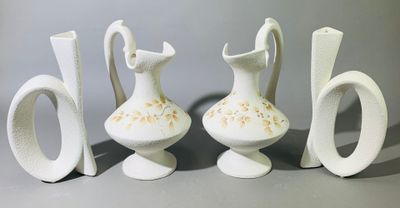 trois vases blancs posés les uns à côté des autres sur une table