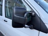 an image of a side view mirror of a white van