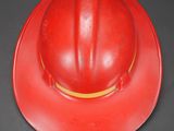 a red fireman ' s hat on a black table