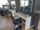 an image of a hair salon with chairs and mirrors