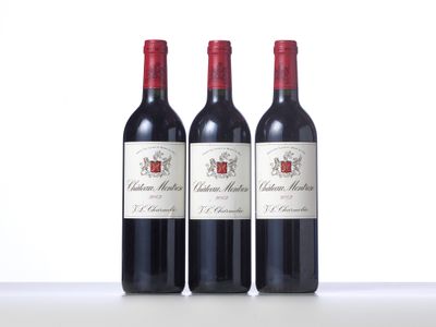 trois bouteilles de vin rouge posées sur une table