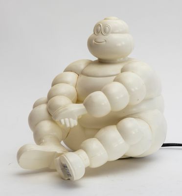une figurine blanche représentant un homme assis par terre
