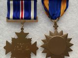 deux médailles sont représentées sur un fond blanc, ornées d'un ruban rouge, blanc et bleu
