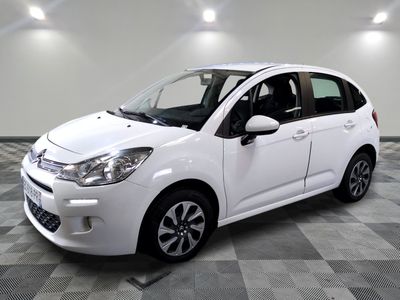 the small white car is parked on a checkered tile floor