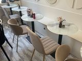 tables and chairs in a room with a clock on the wall