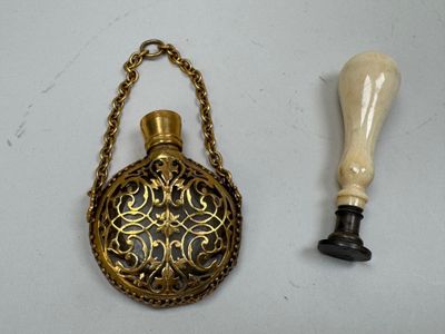 a small brass flask with a chain around it and a wooden handle