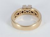 a close up of a gold ring with a diamond in the center