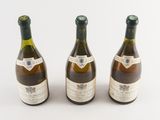 three bottles of wine sitting next to each other on a white surface