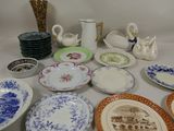 many plates and cups on a table with a vase